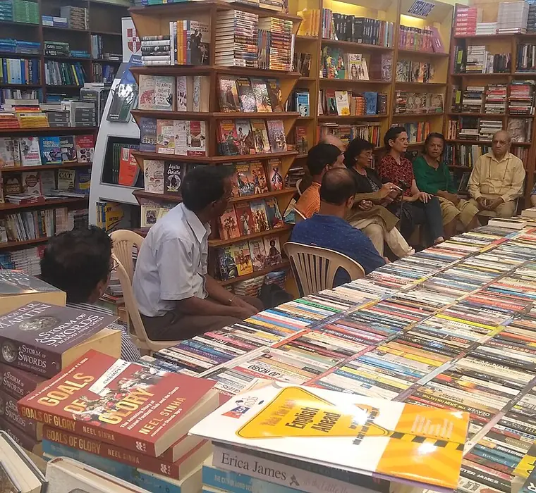 Customers browsing tables of books inside a busy independent bookshop