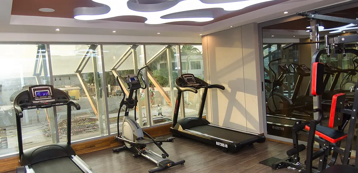 Treadmills and cross trainers on the floor of a daylit gym